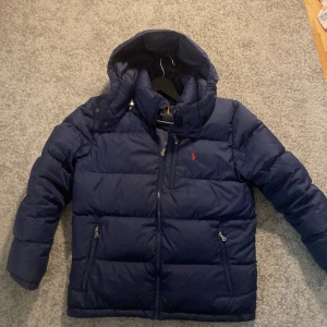 Mörkblå ralph lauren jacka - En jättefin ralph lauren jacka k storlek 14-16 xs Skick 9/10 använd en vinter  En liten defekt med luvan se bild 4  Nypris 4500 