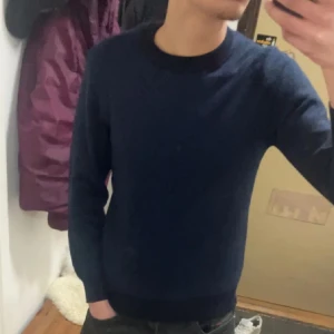 Mörkblå tröja från Sand - Säljer en stilren mörkblå tröja från Sand. Den är perfekt för både vardag och lite finare tillfällen. Tröjan har en klassisk rund hals och är långärmad, vilket gör den superbekväm och lätt att matcha med andra plagg. Passar perfekt nu när det börjar bli lite kyligare ute!