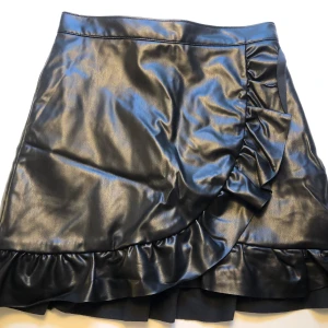 Fejkskinn kort svart kjol - Fejkskinn kort svart kjol, slk 36, oanvänd 