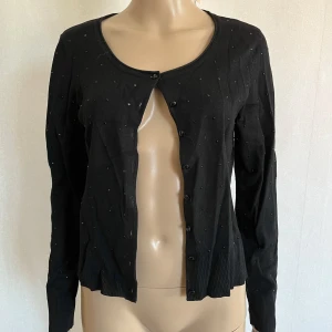 Kofta svart - Några ”stenar” har lossnat