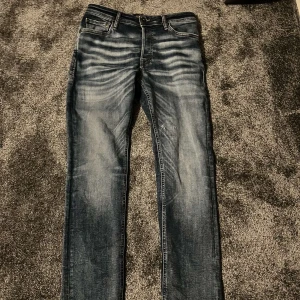Blå Jack&Jones jeans slimfit - Säljer ett par snygga blå jeans med cool fade. Bra skick men som man ser så är de lite sytt på vänstra benet . Hör av er för frågor 😁. 29/32  Längd på modellen: 183cm