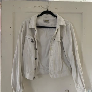 Vit jeansjacka från Rocky - Säljer en snygg vit jeansjacka från Rocky. Den har en klassisk design med knappar framtill och två bröstfickor. Jackan är i storlek S och passar perfekt för vår och sommar. Den är i bra skick och redo för nya äventyr!