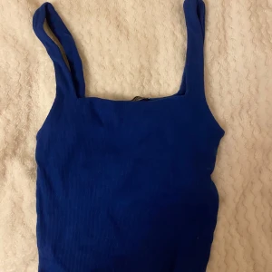 Blå ribbad linnetopp från Zara - Säljer en snygg blå ribbad linnetopp från Zara. Perfekt för sommardagar eller som ett lager under en jacka. Toppen är ärmlös med breda axelband och har en tight passform. Superbekväm och stilren!