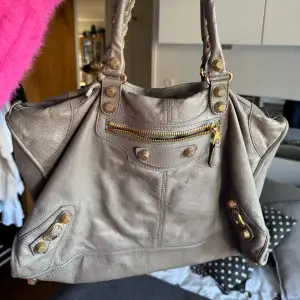 Grå balenciaga citybag med guldiga nitar   Äkthetsbevis finns!  Sparsamt använd - däremot tappat en nit på insidan, se bild.