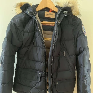 Parajumpers jacka  - En mörkblå parajumpers jacka med avtagbar päls. Jackan är i mycket bra kvalitet och är utan skador. Jackan har 7 fickor varav 4 fram(två med och två utan dragkedja) 2 på insidan samt en innerficka med dragkedja.  Hör av er vid frågor!