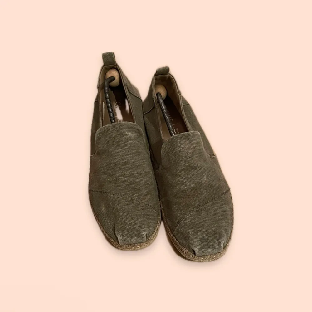 Säljer ett par olivgröna loafers från TOMS i storlek herr 46. Skorna är tillverkade i ett slitstarkt tygmaterial. Perfekta för en avslappnad stil under vår och sommar. De har en klassisk design med en låg sula och är i använt skick.. Skor.