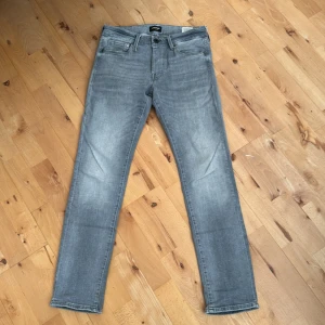 Jack and Jones jeans - Säljer ett par grå jeans från Jack and Jones i modellen slim/Glenn.☺️ De har en klassisk femficksdesign och en diskret tvätt för en cool look. Perfekta för både vardag och fest! Storleken är W29 och L30🤗