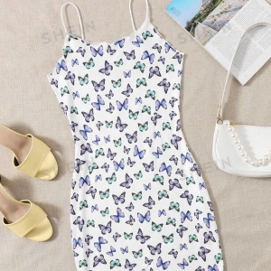 klänning  - vit klänning med fjärilar, slutar strax ovanför knäna.