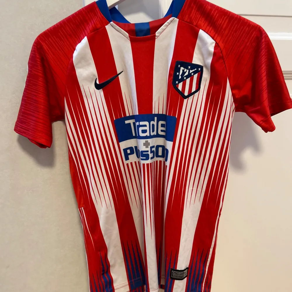 Säljer en Atletico Madrid Med Griezmann på ryggen från 2018! Den är bra skick förutom att laliga loggan på armen har lossnat lite. Jag säljer den för 150kr!. T-shirts.