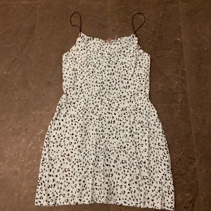 Turkos leopardmönstrad klänning - Snygg turkos klänning med leopardmönster och smala axelband. Perfekt för en trendig look.