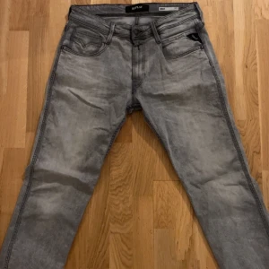 Grå jeans från Replay - Snygga grå jeans från Replay i modellen Anbass. De har en klassisk femficksdesign och en bekväm passform. Perfekta för en stilren look.