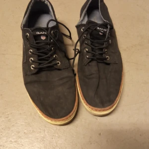 Svarta sneakers från Gant - Snygga svarta sneakers från Gant med snörning och bruna detaljer på hälen. Perfekta för en avslappnad stil.