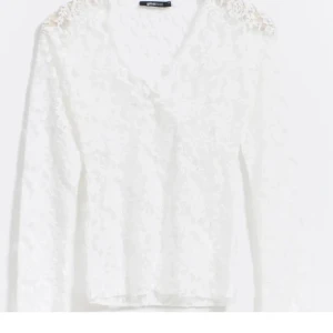 Vit spetsblus - Elegant vit spetsblus från Gina Tricot med v-ringning och långa ärmar. Blusen har ett vackert blommigt mönster. Den är tillverkad i ett mjukt och bekvämt material. Säljer då den inte kommer till användning längre!💕