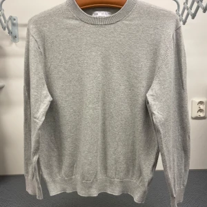 Grå tröja från Zara - Säljer en stilren grå tröja från Zara i storlek 11-12 år. Tröjan har en klassisk rund halsringning och långa ärmar. Perfekt för både skola och fritid.