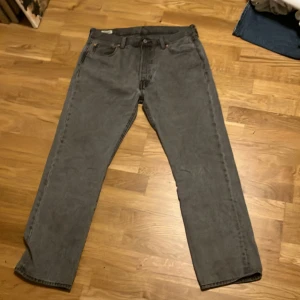 Grå Levis 501 jeans - Säljer ett par klassiska grå Levis 501 jeans. De har en rak passform och är tillverkade i slitstarkt denim. Perfekta för en avslappnad stil.