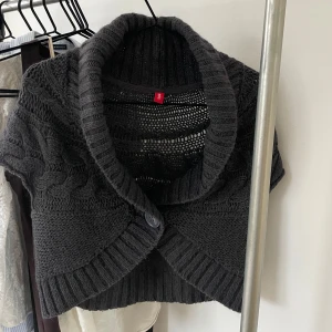 Mörkgrå stickad bolerotopp - Säljer en varm mörkgrå stickad bolerotopp med korta ärmar och en stor krage. Toppen har ett fint flätmönster och en knapp framtill. Mohairbladning (15%) Perfekt för lager-på-lager! Kan mötas upp i Sthlm, annars står köparen för frakten 🩷