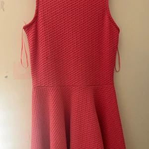 Röd och blå klänning från Sinsay - Två ärmlösa klänningar från Sinsay i rosa och blå färg. De har en texturerad yta och en skatermodell som ger en fin form. Perfekt för sommarens alla tillfällen. 300kr för båda 150kr för en av dom.