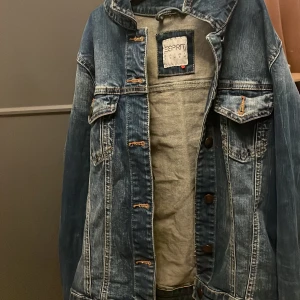 Blå jeansjacka från Esprit - Snygg blå jeansjacka från Esprit med klassisk design. Jackan har knappar framtill och två bröstfickor med lock. Perfekt för en avslappnad stil.