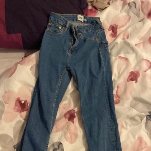 Blå jeansbyxor - Säljer ett par klassiska blå jeansbyxor med hög midja och skinny passform. Perfekta för en stilren look.
