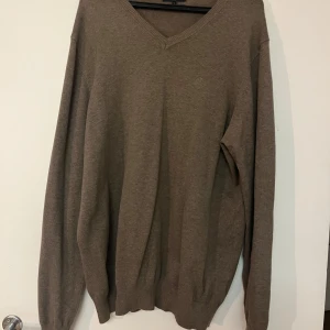 Brun tröja från Henri Lloyd - Säljer en stilren brun tröja från Henri Lloyd i storlek XL. Tröjan har en v-ringad hals och är tillverkad i bomull. Perfekt för en avslappnad och klassisk look.