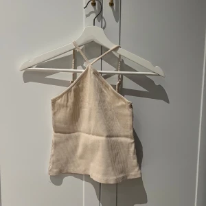 Beige ribbad linnetopp från Bik Bok - Supergullig beige ribbad topp med halterneck från Bik Bok🤍 Justerbara band i ryggen! Storlek XS😇