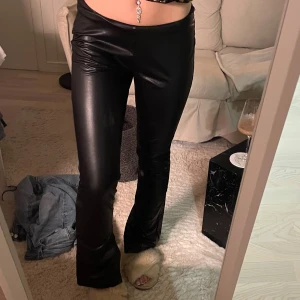 Svarta skinnbyxor - Snygga svarta skinnbyxor midrise  och bootcut-stil.