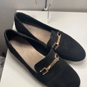 Svarta loafers med gulddetalj - Snygga svarta loafers med en snygg gulddetalj på ovansidan. Så snygga och lätta att matcha till allt! 😍😍 i mockaimitation 