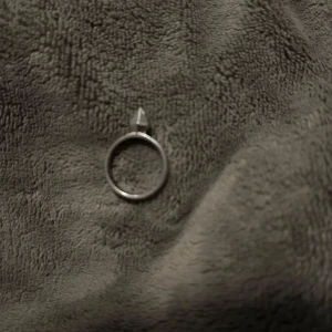 Silverfärgad ring med en unik nit  - Stilren ring i silverfärg med en unik nit detalj på toppen. Perfekt för att ge en edgy touch till din stil.