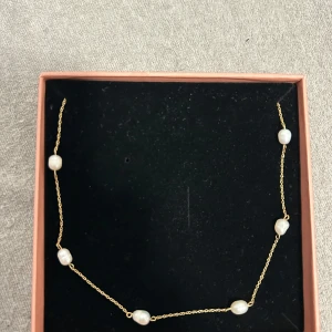 Guldhalsband med pärlor från Edblad - Elegant guldhalsband från Edblad med vita pärlor. Väldigt fint och knappt använt