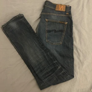 Nudie jeans (Grim tim) - Mörkblå Nudie jeans i storlek W 33 L 34, dem är i bra skick men har behövt sy dem främre fickorna då det var hål i dem Men annars är dem i bra skick