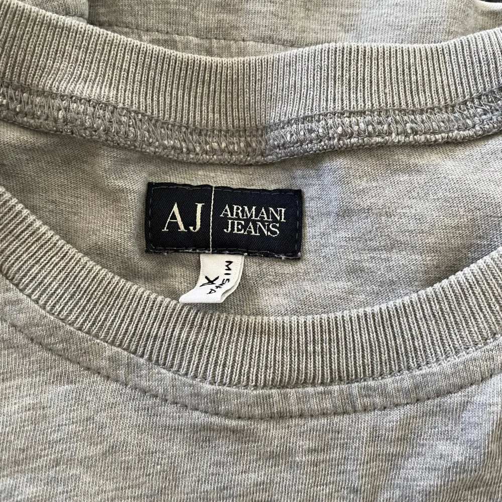 Mycket fin Armani Jeans T-Shirt, den kommer med något jag gillar text på ryggen som är väldigt snyggt. Skicket är bra förutom att trycket är slitet men den är ändån fin. Storlek XL men skitter bra på M.Pris går att diskuteras. . T-shirts.