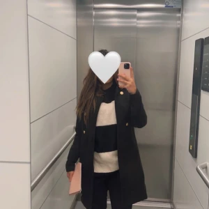 Svart och vit randig stickad tröja - Säljer en supermysig svart och vit randig stickad tröja. Den är perfekt för höst och vinter, och har en normal passform. Tröjan har långa ärmar och är riktigt skön att ha på sig. Perfekt för både vardag och fest!