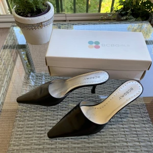 Svarta pumps från BCBGirls - Säljer ett par svarta pumps från BCBGirls. Skorna har en spetsig tå och en liten klack. De är tillverkade i mjukt skinn. Mycket välvårdade.