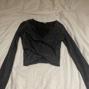 glittrig hm topp criss cross - H&M glitter topp som går i criss cross vid magen! Super fin och i bra skick! Ställ gärna frågor 🩷