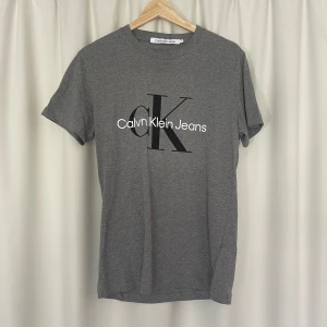 Calvin klein T-shirt  - Hej! Säljer nu den här gråa t-shirten från Calvin Klein i riktigt bra skick! Passar storlek S och kommer vara riktigt snygg nu till hösten. Nypris ca 600kr.