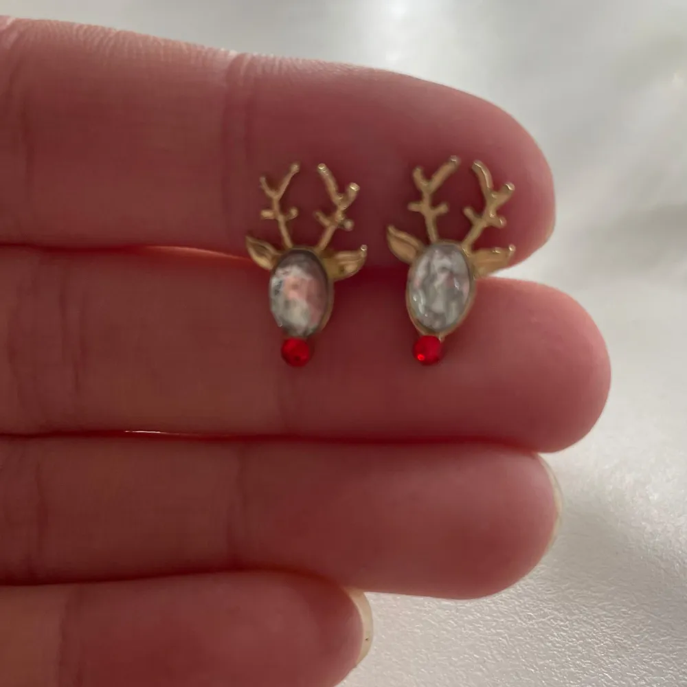 Säljer ett par supergulliga örhängen i form av renar. De är guldiga med vita pärlor som huvuden och små röda detaljer som näsor. Perfekta för jul och vintersäsongen! 🦌✨ minns inte vad jag köpte de för men säljer för 15kr/st kan gå ner i pris också! rengörs med alsolsprit innan de säljs! tryck INTE på köp nu utan att prata med mig först.. Accessoarer.