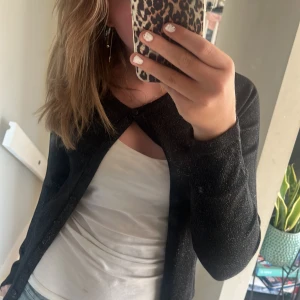 Svart glittrig kofta från Saint Tropez - Säljer en snygg svart glittrig kofta från Saint Tropez i storlek S. Koftan har långa ärmar och knappar framtill. Perfekt för både vardag och fest! ✨