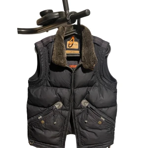 Parajumper väst! Säljs ej längre  - Säljer en svart sällsynt parajumper väst som inte säljs längre. Västen har en mysig päls på kragen och flera praktiska fickor med dragkedja och knappar. Perfekt för höst och vinter!