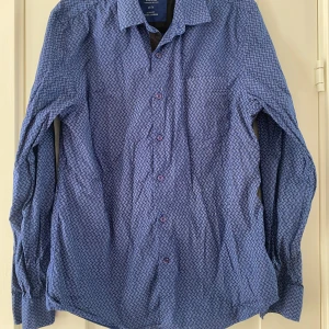 Marinblå mönstrad skjorta från Guess i strl M, slim fit - Marinblå mönstrad skjorta från Guess i strl M, slim fit.  Sparsamt använd och i fint begagnat skick.  Mått Över bröstet: ca 53 cm Längd från axeln och ner: ca 73 cm  97% bomull och 3% elastan  Kommer från ett djur och rökfritt hem.