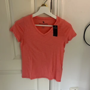 Rosa v-ringad t-shirt - Fin rosa t-shorts från abercrombir kids, 11-12 men passar bra som storlek xs. Oanvänd med lapp kvar.