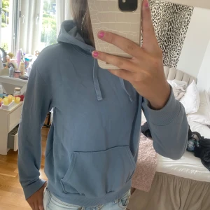 Blå hoodie - Säljer en supermysig blå hoodie. Den är perfekt för kyliga dagar och har en stor ficka fram och en justerbar huva. Materialet är mjukt och bekvämt, och den har långa ärmar med ribbade muddar. Passar perfekt till jeans!