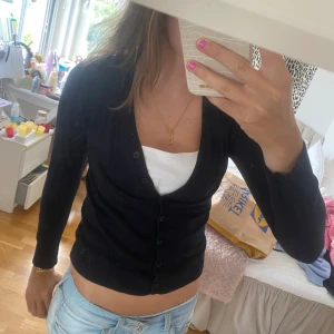 Svart kofta - Säljer en svart kofta i storlek xs/s. Den är perfekt för höst och vår, med en normal passform och långa ärmar. Koftan har knappar framtill och är gjord av ett mjukt och bekvämt material. Perfekt att ha över en topp eller t-shirt!