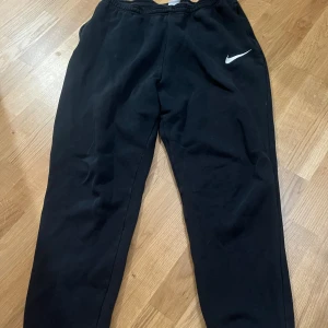 Svarta mjukisbyxor från Nike - Säljer mina svarta Nike mjukisbyxor då dem inte kommer till nån användning. Dem är i storlek L och är perfekt i längd för mig som är ungefär 171cm lång.💕