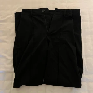 Svarta kostymbyxor från Pull&Bear - Säljer ett par svarta kostymbyxor från Pull&Bear i storlek XS. Byxorna är högmidjade och har en rak passform. Perfekta för både vardag och fest!