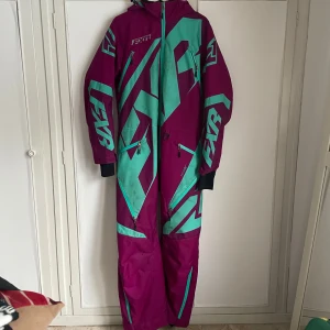 Skoteroverall - Jättefin skoteroverall från FXR, nytvättad men har några fläckar på framsidan (se bild) inköpt för några år sedan men är varsamt använd så förutom fläktarna är den hel, det är en skal overall!