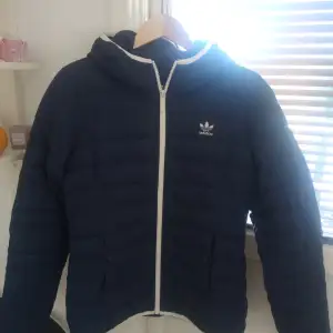 Säljer en marinblå adidas jacka i strl M, den har fått lite smink på sig kolla 3 bilden (går bort i tvätten) det har läckt något i ena fickan som har stelnat men det går 100% bort om man tvättar det (bild 4)! Den har ett jätte litet hål där bak, syns knappt och kommer ej synas om man har sytt det lila hålet (kolla sista bilden), annars är jackan i mycket bra skick! Säljer den för 500kr + frakt!