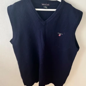 Stickad väst från Gant - Jättefin marinblå sticka väst/slipover från Gant. Passar perfekt till outfits nu under höst och vinter. Materialet är 100% lambswool. 