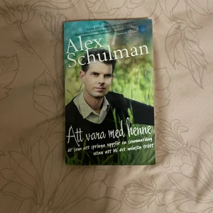 Att vara med henne - Boken 'Att vara med henne' av Alex Schulman handlar om en personlig och känslosam berättelse. Omslaget är grönt med en bild av författaren i en somrig miljö. Texten på framsidan beskriver en känsla av lätthet och glädje. Perfekt för den som gillar biografier och kärlekshistorier.