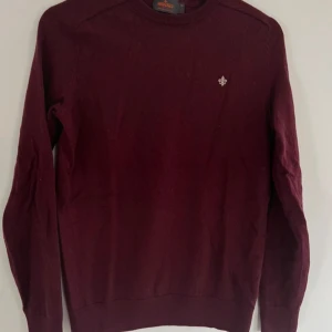 Vinröd tröja från Morris - Säljer en stilren vinröd tröja från Morris i merinoull. Perfekt för höst och vinter med sin mjuka och varma känsla. Tröjan har en liten broderad detalj på bröstet och är långärmad. Passar både till vardags och festliga tillfällen. Är m men passar nog mer s men även tight m