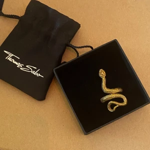 Thomas Sabo snake ring guld - Fick denna i studentpresent för 4 år sen så vet inte vad nypriset kan ha varit. Vad jag hittar är 999 för en liknande ny. Den är oanvänd, går att justera storleken om man klämmer åt/drar ut den.